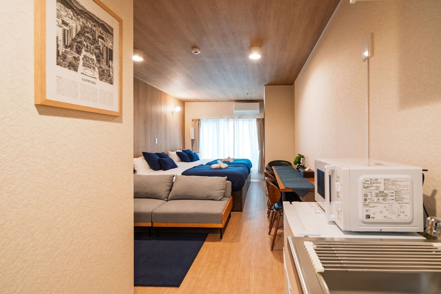 Bright, Comfortable, and Fully Equipped!
Spacious studio with a large bed, cozy sofa, and a stylish dining/workspace for up to 5 people.
Perfect for relaxing, working remotely, or enjoying a meal after a day in Sapporo.